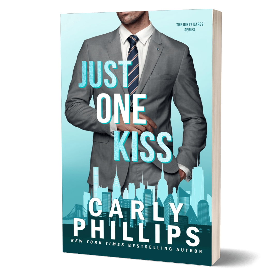 Book cover of 'Just One Kiss' by Carly Phillips with a man in a suit against a city skyline.